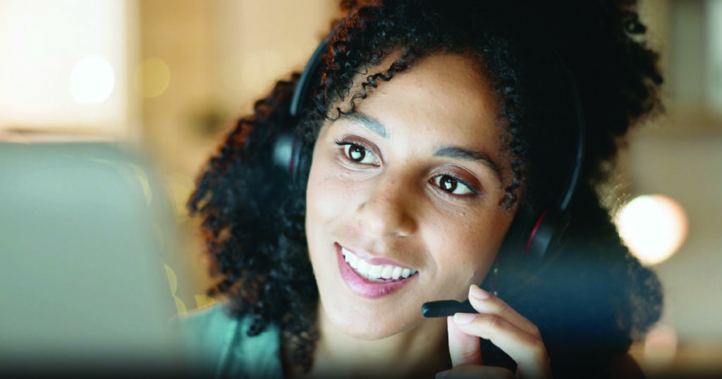 Closeup image of a customer support agent on a call with a headset microphone.